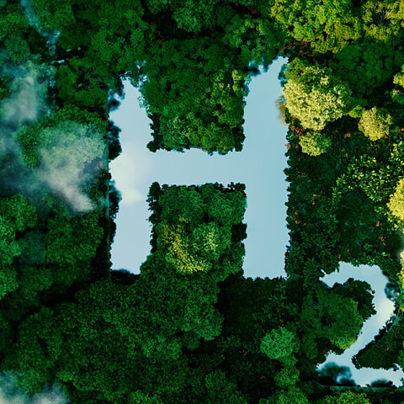 Chemisches Zeichen für Wasserstoff über Bäumen und Wolken